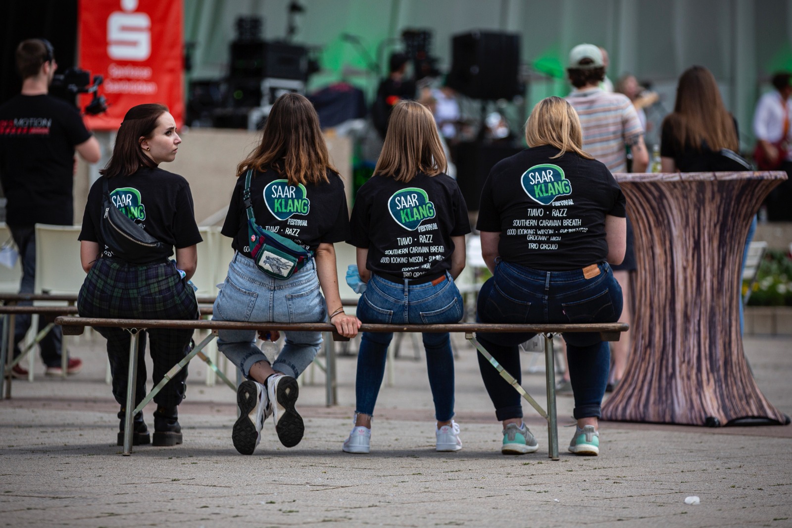 Saarklang Festival: Das Bild zeigt die Rücken einiger Teammitglieder, die auf einer Bank sitze.