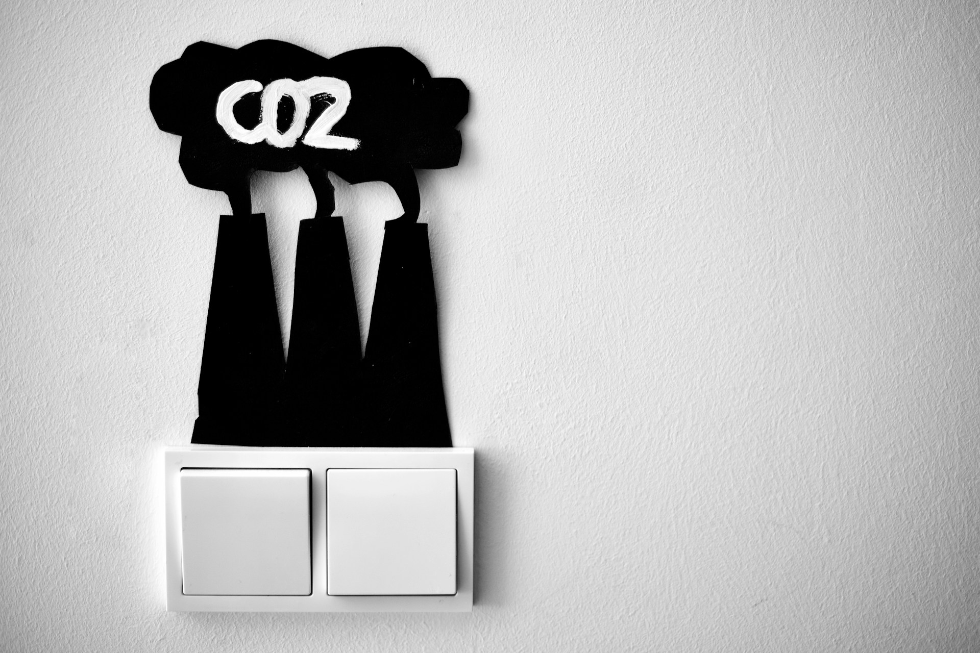 Abbildung von CO2-emittierenden Schornsteinen über Lichtschaltern.