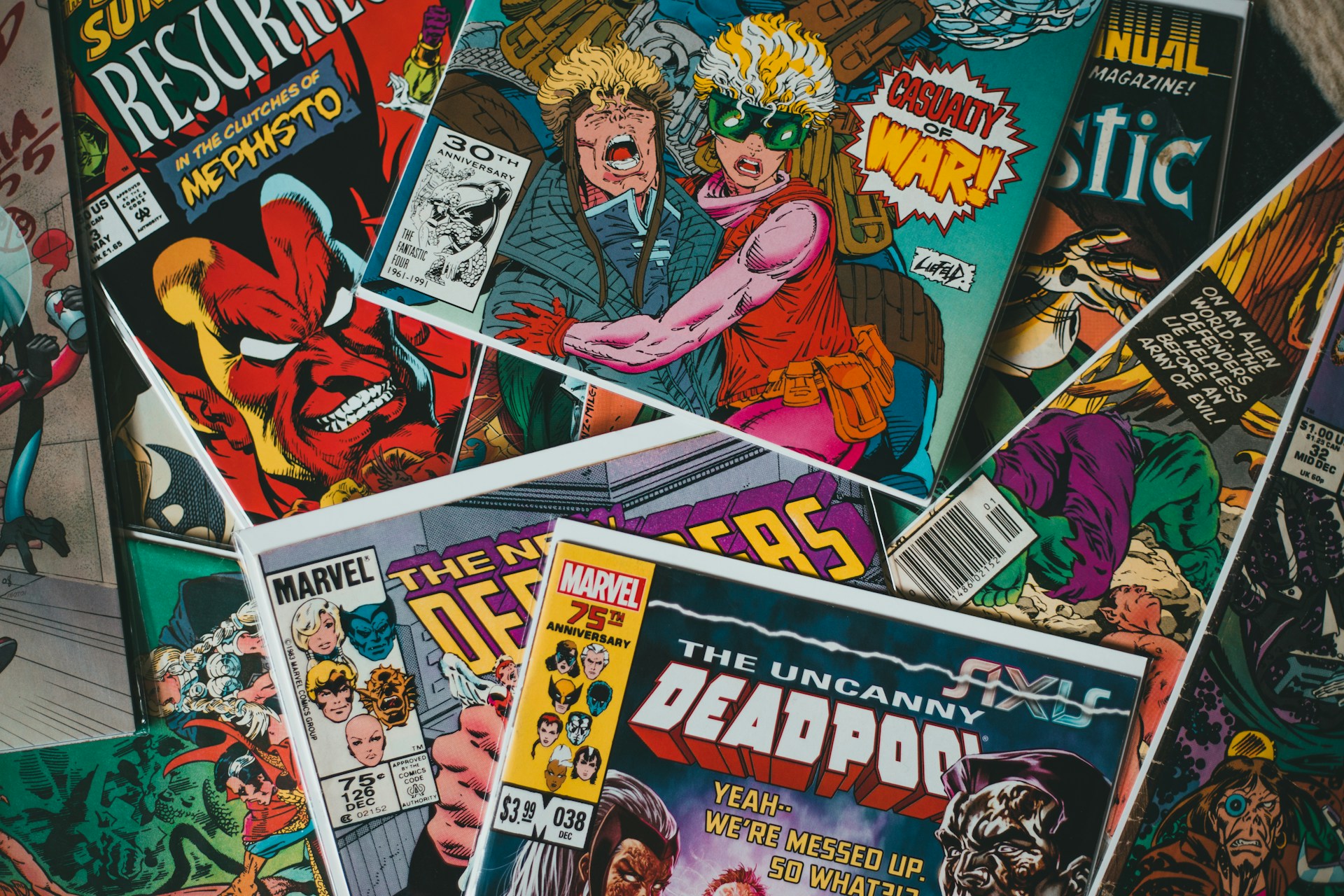 Ein Stapel bunter Marvel-Comics mit verschiedenen Superheld:innen und Schurken auf den Covern, darunter »The Uncanny Deadpool« und »The New Defenders«.
