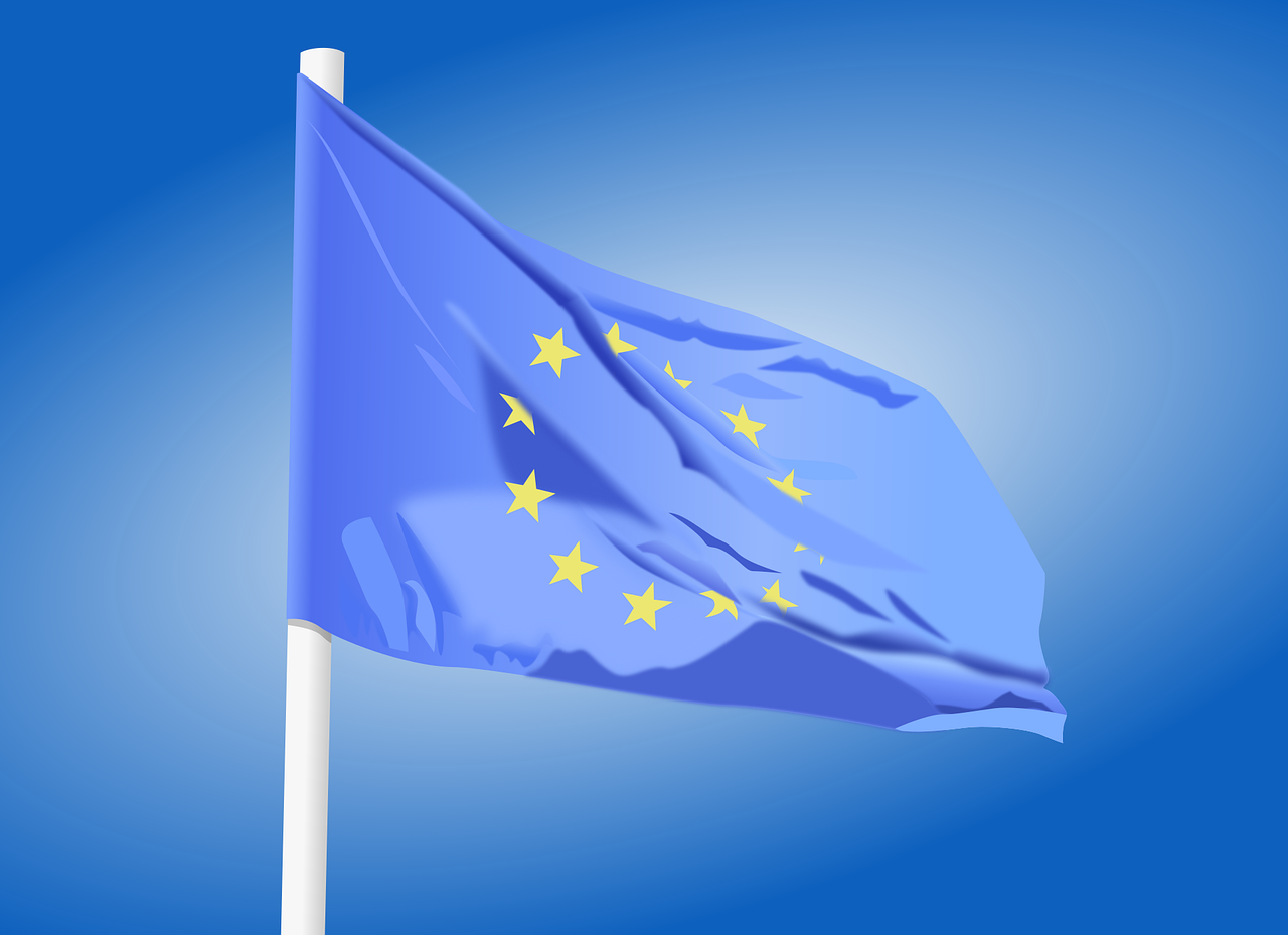 Illustration einer wehenden Europaflagge an einem weißen Fahnenmast auf blauem Hintergrund. Die Flagge ist blau mit einem Kreis aus zwölf gelben Sternen in der Mitte, symbolisch für die Einheit und Solidarität Europas.