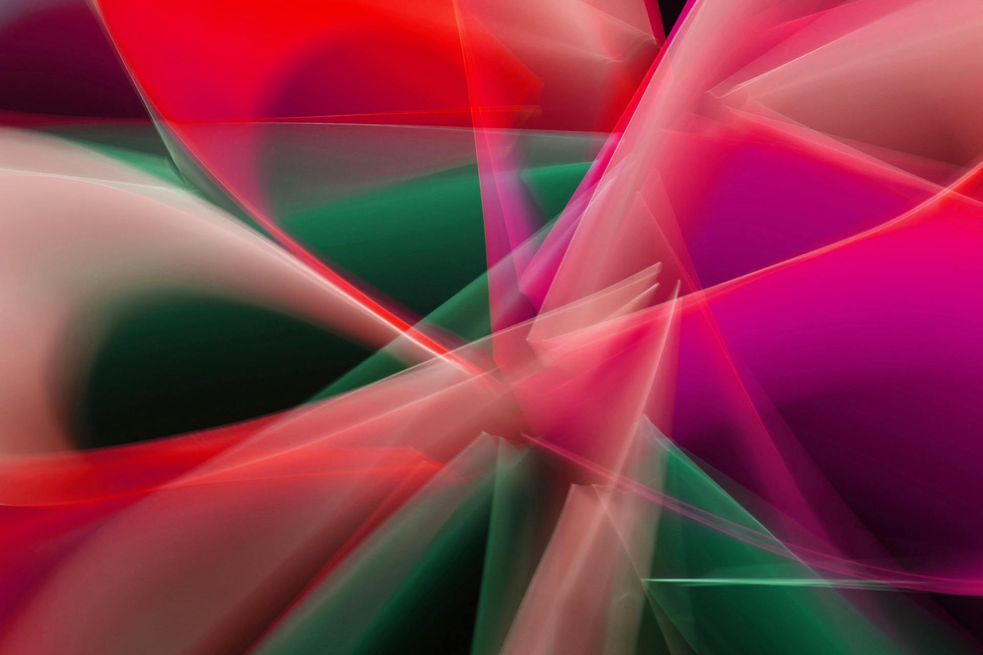 Abstrakte digitale Komposition aus durchscheinenden geometrischen Formen in leuchtenden Farben. Überlappende transparente Flächen in Rot, Pink, Magenta, Grün und Weiß erzeugen ein dynamisches, dreidimensionales Muster mit weichen Farbverläufen und scharfen Lichtlinien.