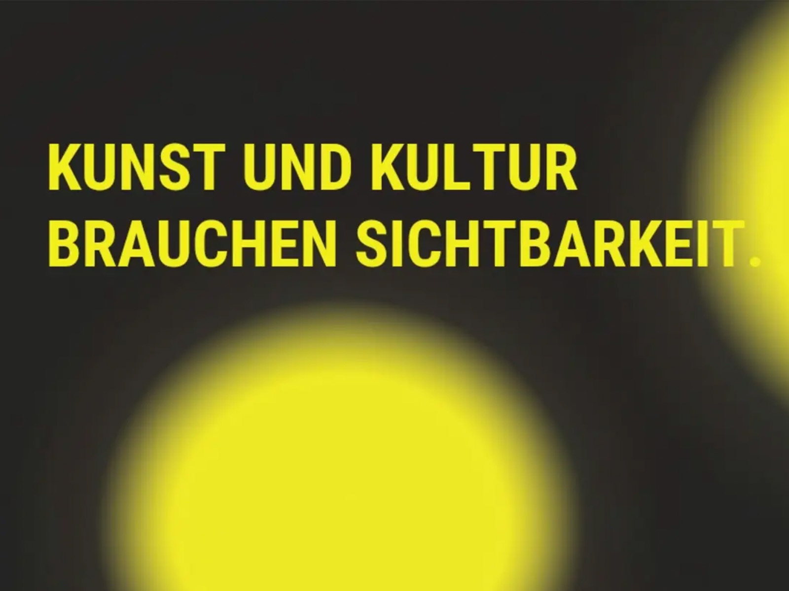 Grafische Kachel mit schwarzem Hintergrund und zwei weichen, leuchtend gelben Lichtkreisen – einem großen unten mittig und einem kleineren oben rechts. In fettem Gelb steht der Satz „KUNST UND KULTUR BRAUCHEN SICHTBARKEIT."