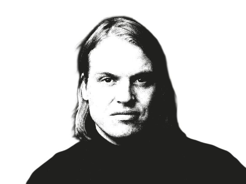 Schwarz-weißes, stark kontrastiertes Porträtfoto einer Person mit schulterlangem Haar und ernstem Blick vor weißem Hintergrund. Die Person trägt ein schwarzes Oberteil. Das Bild hat einen grafischen, druckähnlichen Charakter. Foto: Walther Le Kon.