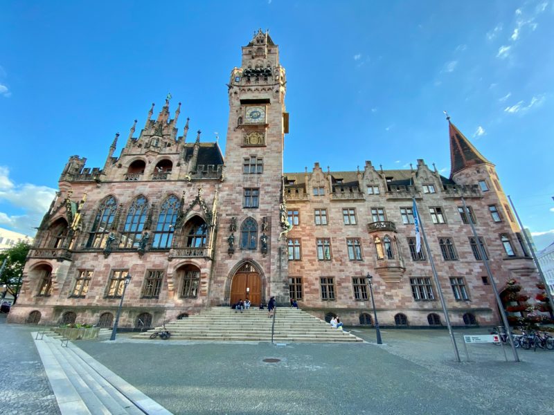 »Das Rathaus St. Johann in Saarbrücken«: Historisches Gebäude im neugotischen Stil, mit markantem Glockenturm, detailreicher Fassade und zentralem Standort am Rathausplatz.