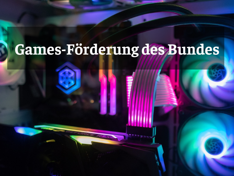 Ein Gaming-PC mit bunter RGB-Beleuchtung, sichtbaren Kühlventilatoren und Verkabelung. Darüber liegt eine transparente Textbox mit der Aufschrift „Games-Förderung des Bundes“.