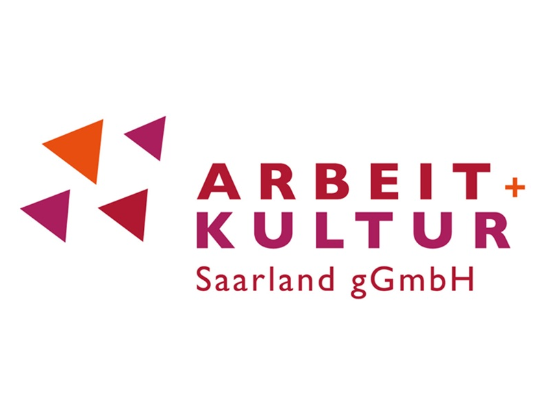 Logo von ARBEIT+KULTUR Saarland gGmbH auf weißem Hintergrund. Links befinden sich vier Dreiecke in Orange und Pink, die ein abstraktes Symbol bilden. Rechts daneben steht der Schriftzug 'ARBEIT+KULTUR' in Großbuchstaben in Rot- und Pinktönen, darunter 'Saarland gGmbH' in kleinerer Schrift.